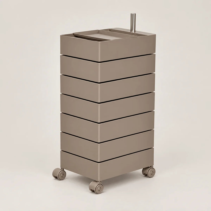 A modern, minimalist rolling storage cart with seven stacked drawers in a warm taupe-brown finish, featuring a matching top tray and dual metal handles, set against a solid light gray background.