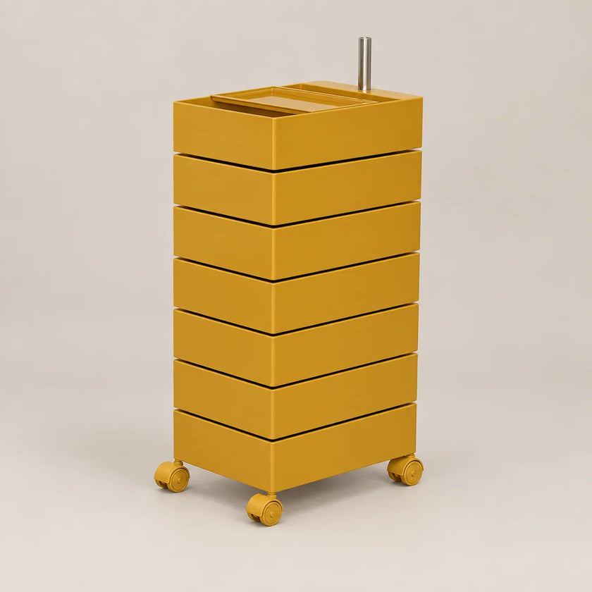 A mustard yellow rolling storage cabinet with six stacked drawers and a metal handle on top, shown on a plain light beige studio background.