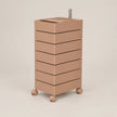 A minimalist, modern rolling storage cabinet with six stacked drawers in a warm taupe-brown color, featuring a matching top tray and small wheels, set against a solid light beige background.