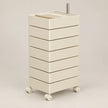 An off-white plastic rolling storage cart with six drawers, four caster wheels, and a metal handle on top, shown against a neutral light gray background.