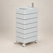 A white rolling storage cart with six stacked drawers, a top tray, and caster wheels, shown on a plain beige studio background.