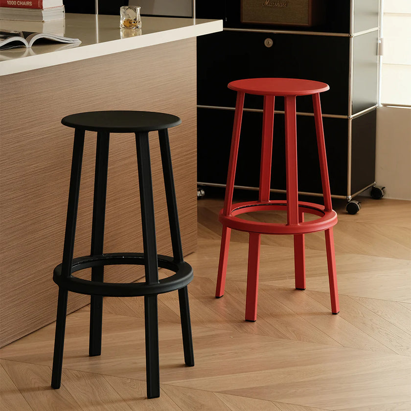 Black and red bar stools on a wooden floor with a blurred background
