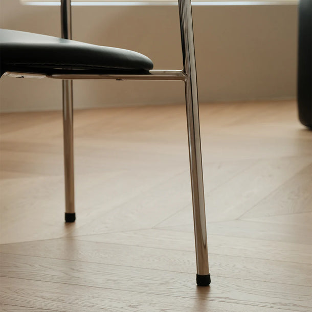 Close-up of a chair leg on a wooden floor with a blurred background