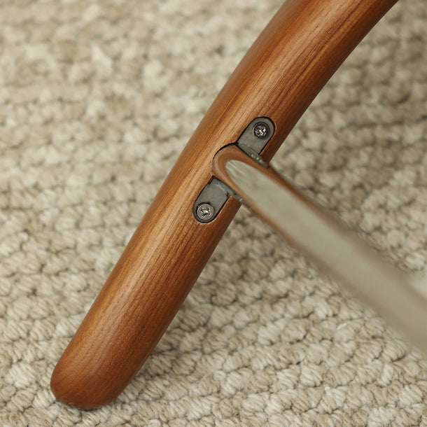 Close-up of a wooden handle with metal brackets on a beige carpet