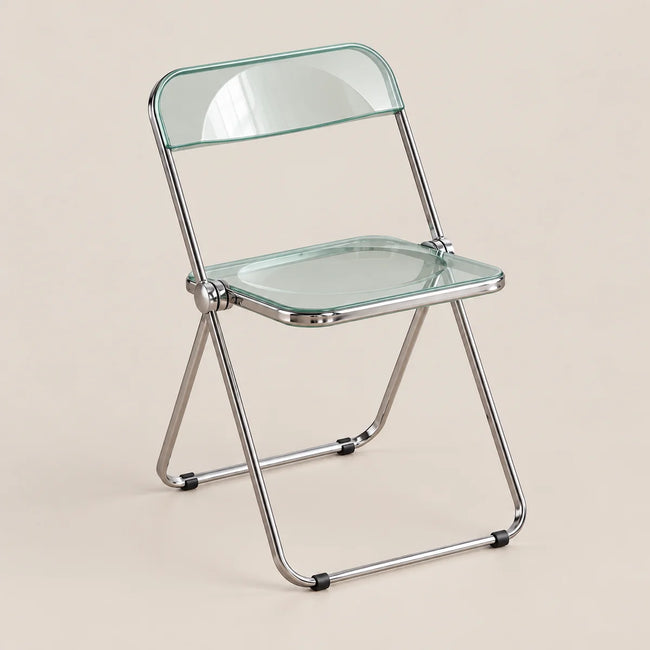 A folding chair with a clear glass seat and backrest on a chrome metal frame, set against a solid beige background.