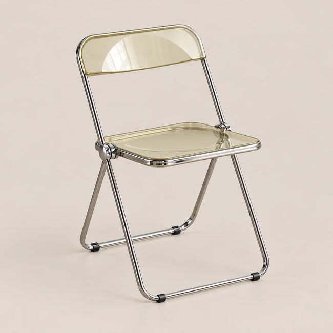 A modern folding chair with a transparent, frosted pale yellow seat and backrest, supported by a polished chrome metal frame, set against a solid beige background.