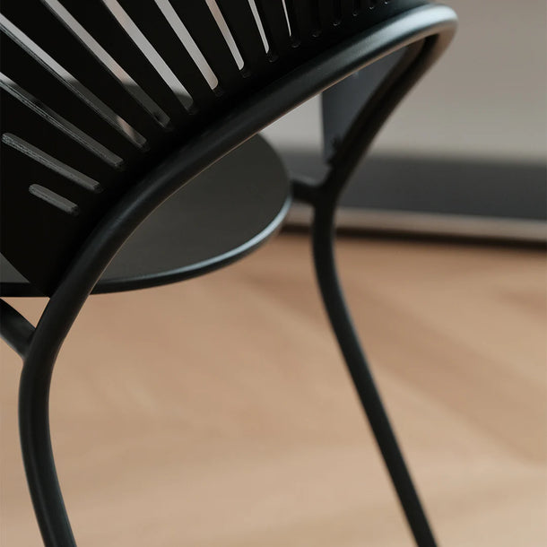 Close-up of a black metal chair on a wooden floor