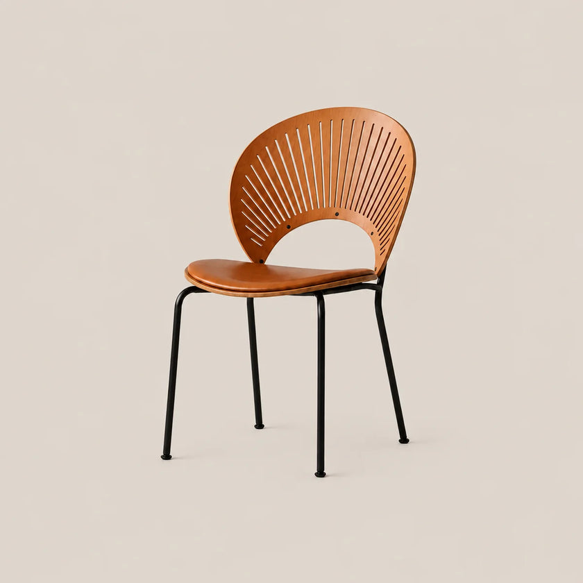 A modern accent chair with a curved backrest made of slatted wood in a warm tan finish, a matching wood seat, and slim black metal legs, set against a solid light beige background.