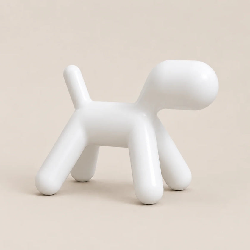 A minimalist white ceramic dog-shaped stool with a glossy finish, set against a solid beige background.