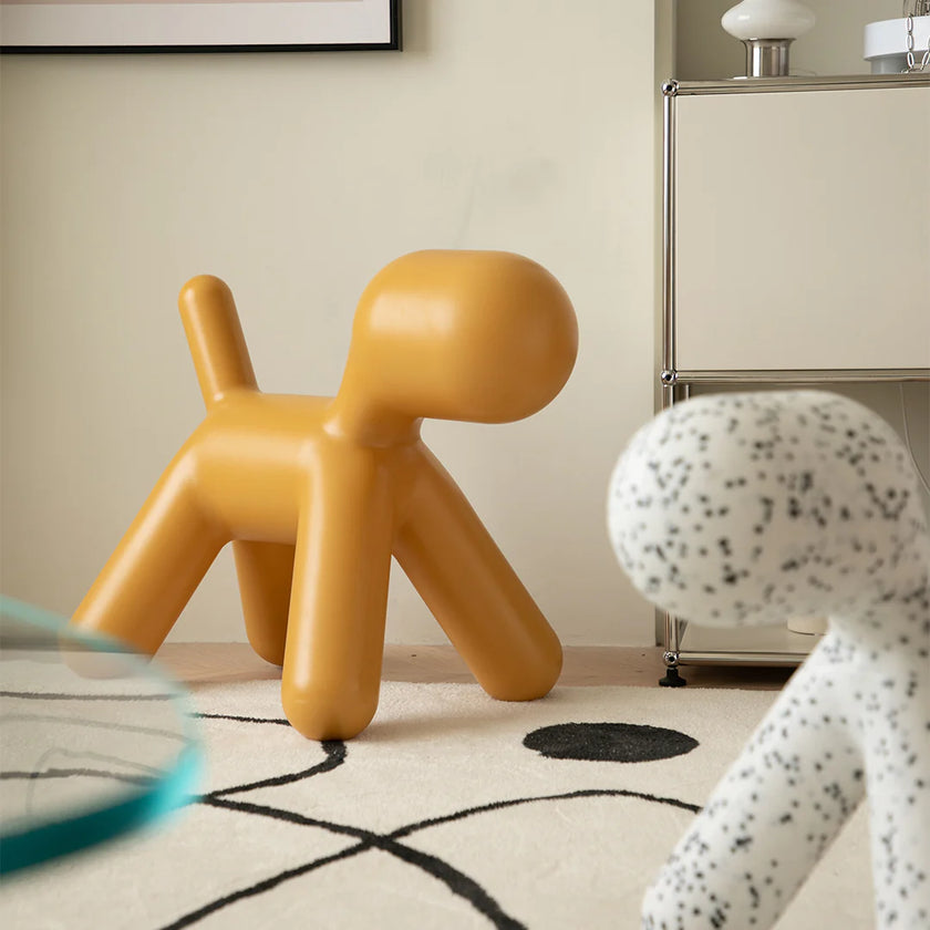 Yellow dog-shaped chair in a room with a lamp and abstract rug.