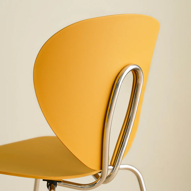 Yellow chair with a metal frame on a beige background