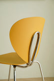 Yellow chair with metal frame against a plain background