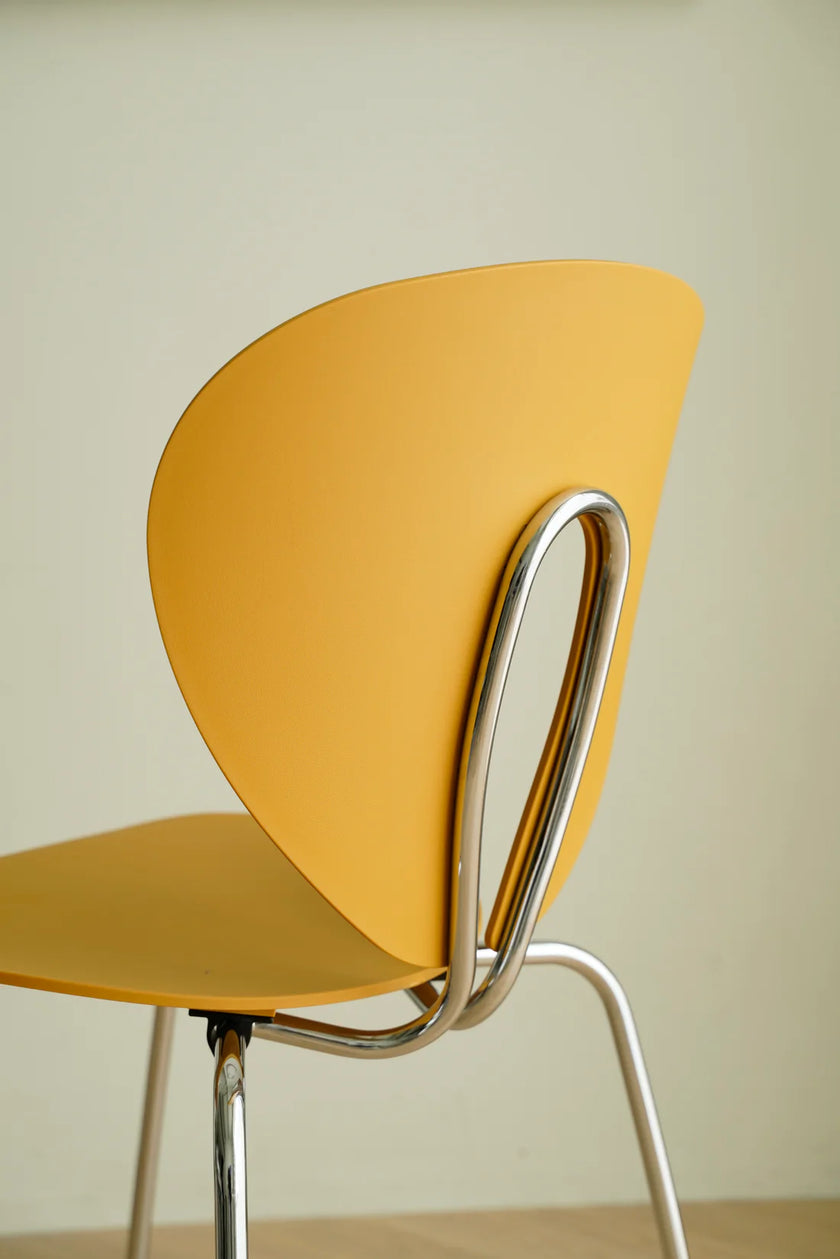 Yellow chair with metal frame against a plain background