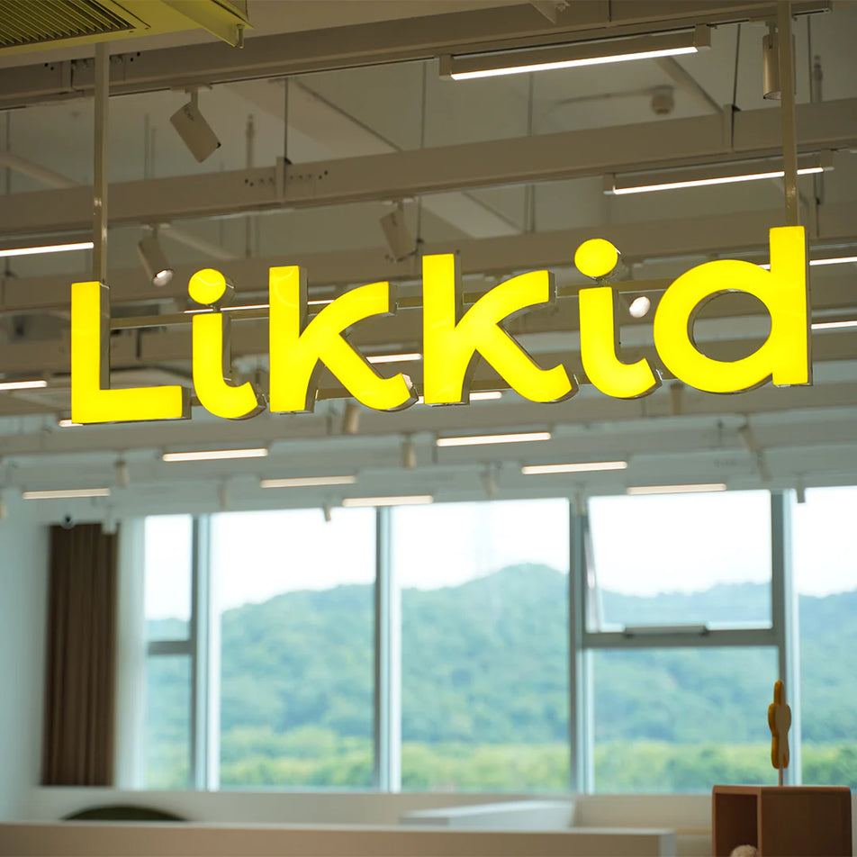 Yellow 'Likkid' sign in an office with a view of mountains