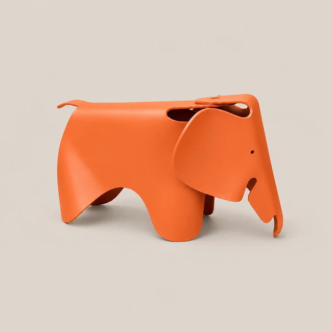 An orange elephant-shaped stool with a matte finish, shown from a side profile against a solid light beige background.