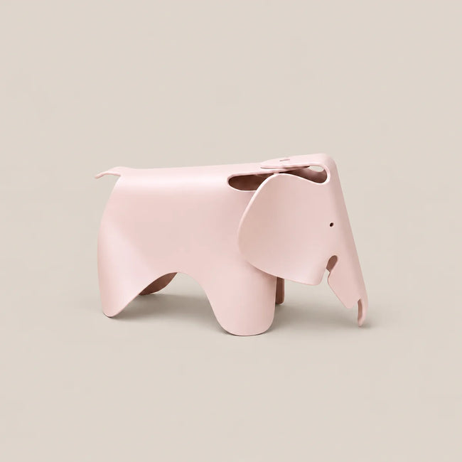 A light pink elephant-shaped stool with a minimalist, sculptural design, shown on a solid beige background.
