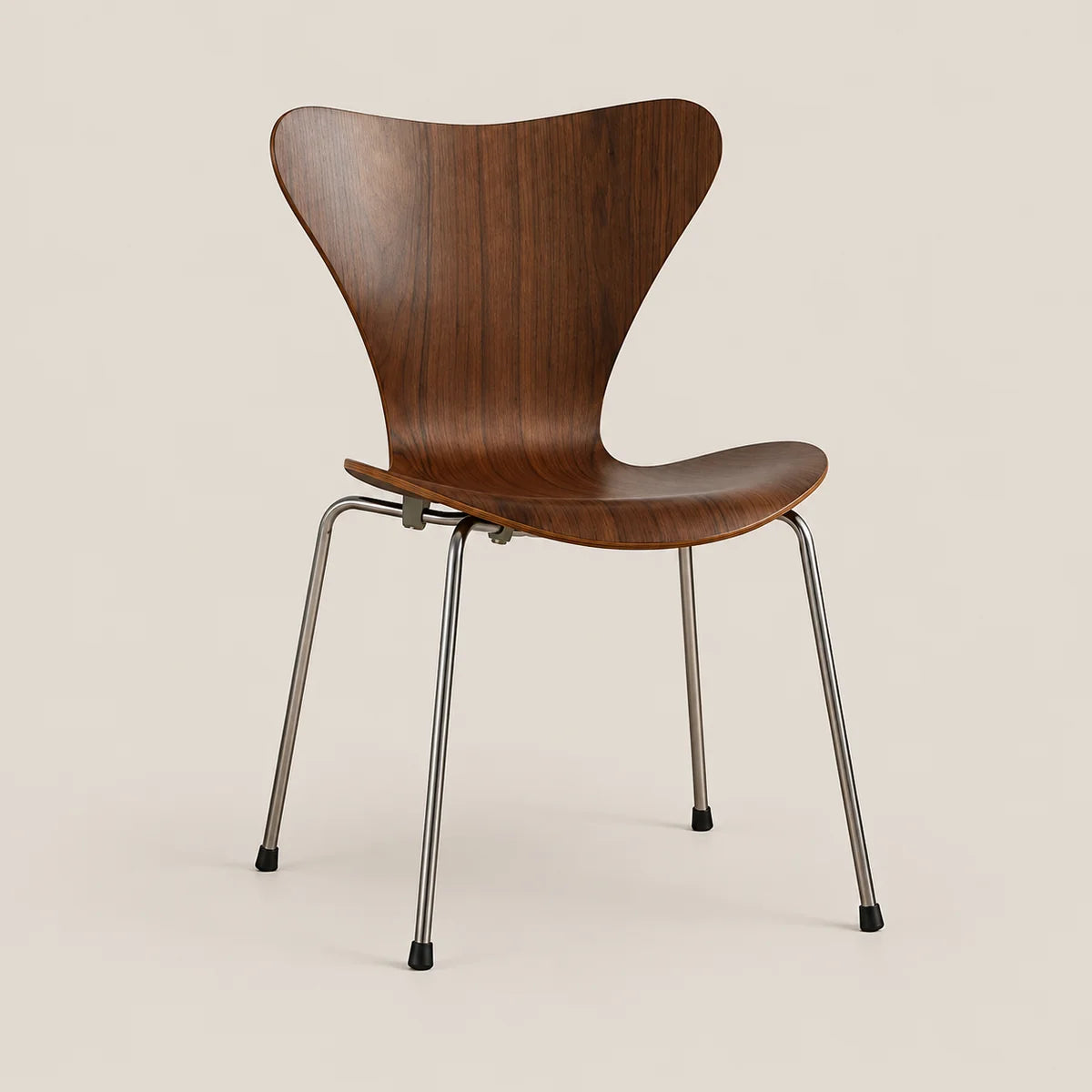 A mid-century modern wooden dining chair with a curved walnut-look wood shell and slim chrome legs, shown against a solid light beige background.
