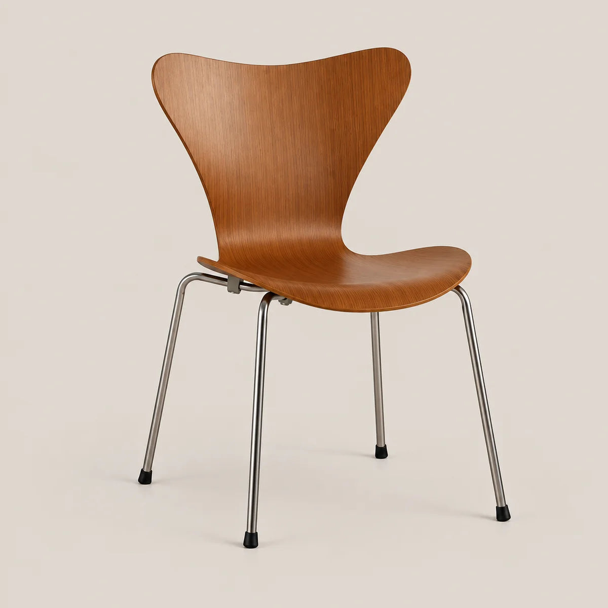 A mid-century modern style chair with a curved, sculptural wooden seat and backrest, supported by slim chrome metal legs with black rubber feet, set against a solid light beige background.