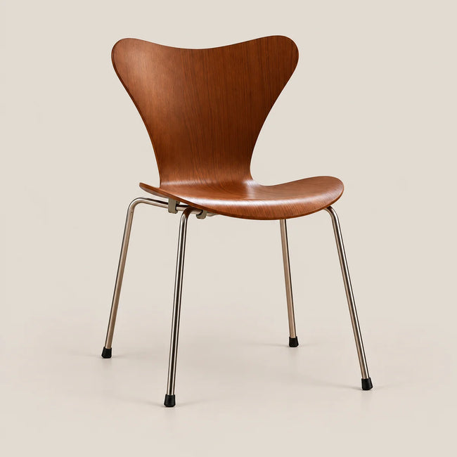 A mid-century modern chair with a curved, sculptural wooden shell seat and backrest, supported by slim chrome legs with black rubber feet, set against a solid light beige background.