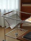 Metal wire cart with a perforated design on a wooden surface.