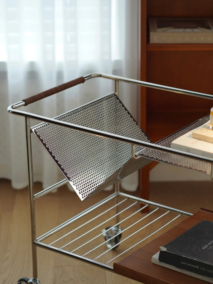 Metal wire cart with a perforated design on a wooden surface.