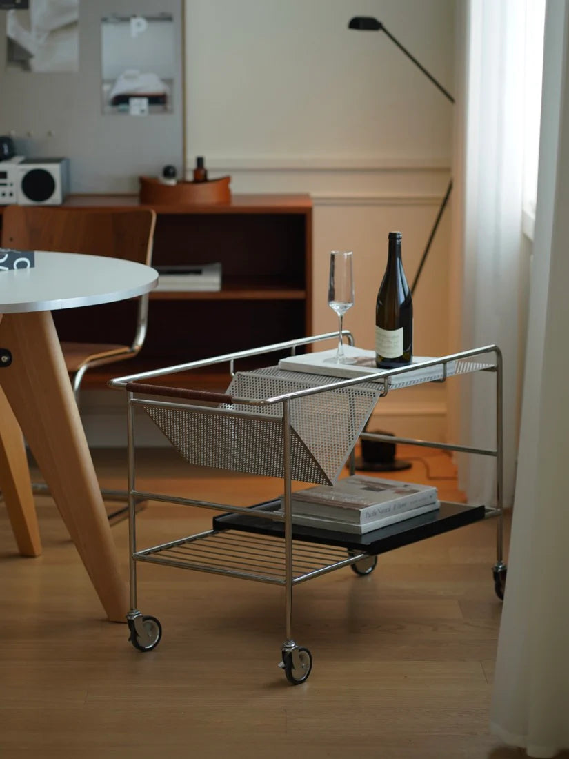 Metal serving cart with a bottle of wine and glasses in a room setting.