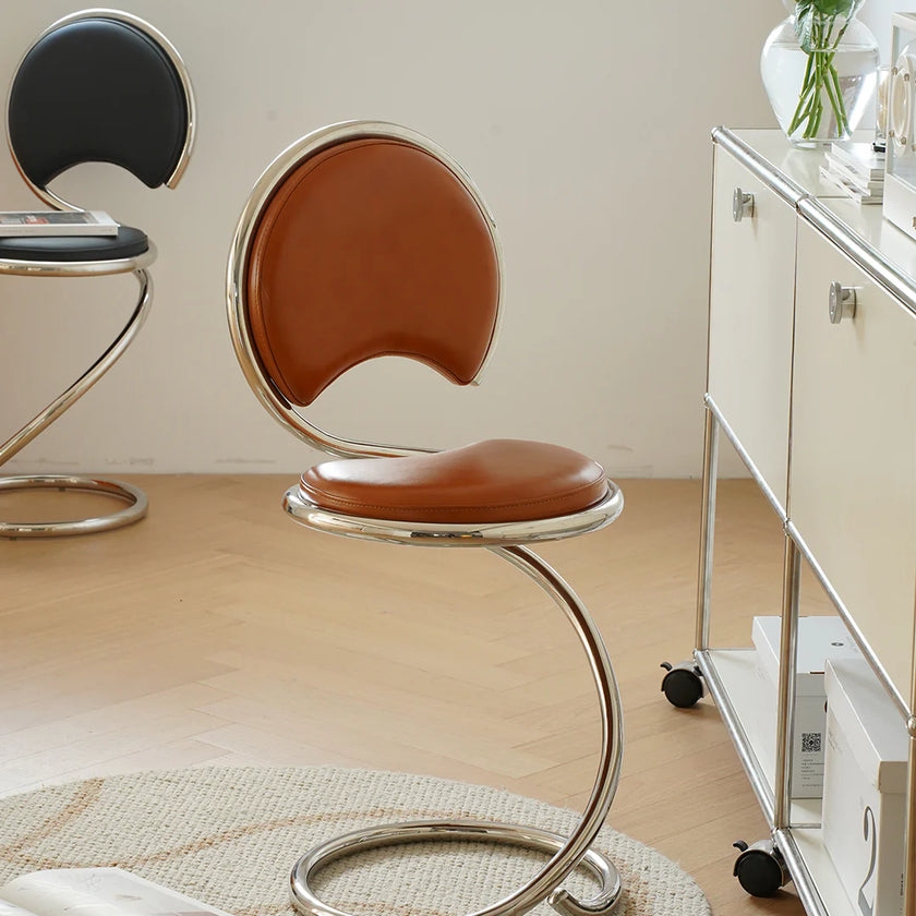 Modern chair with brown seat and metal frame in a room setting.