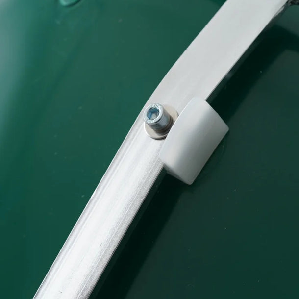 Close-up of a green vehicle with a silver handle and screw detail