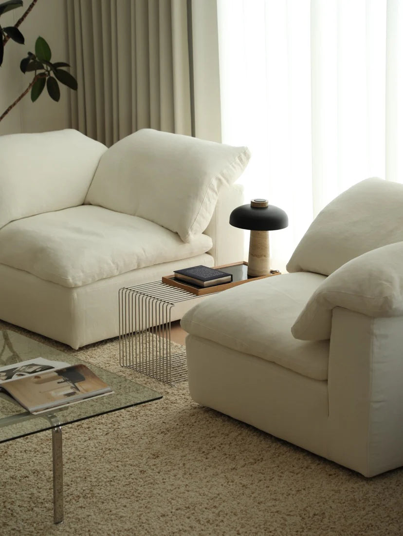 Modern living room with white sofas and a glass coffee table.