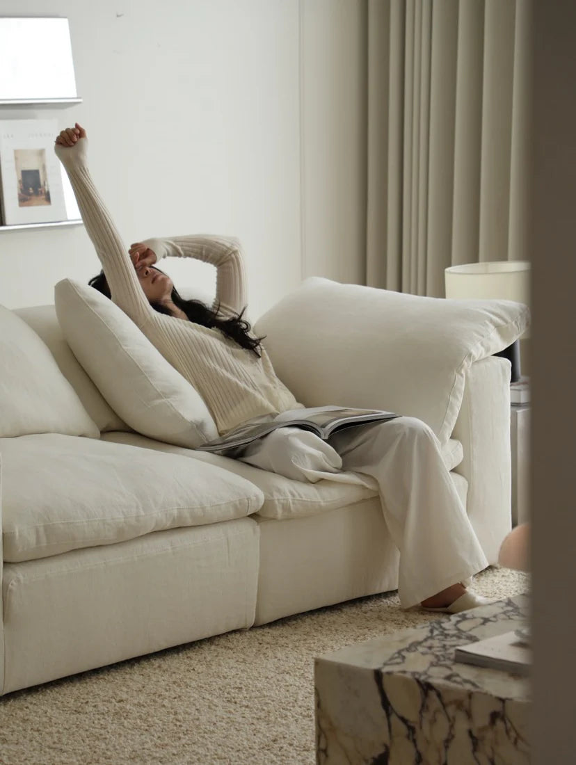 Person sitting on a white couch in a bright living room