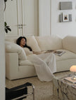 Woman lying on a white couch in a modern living room