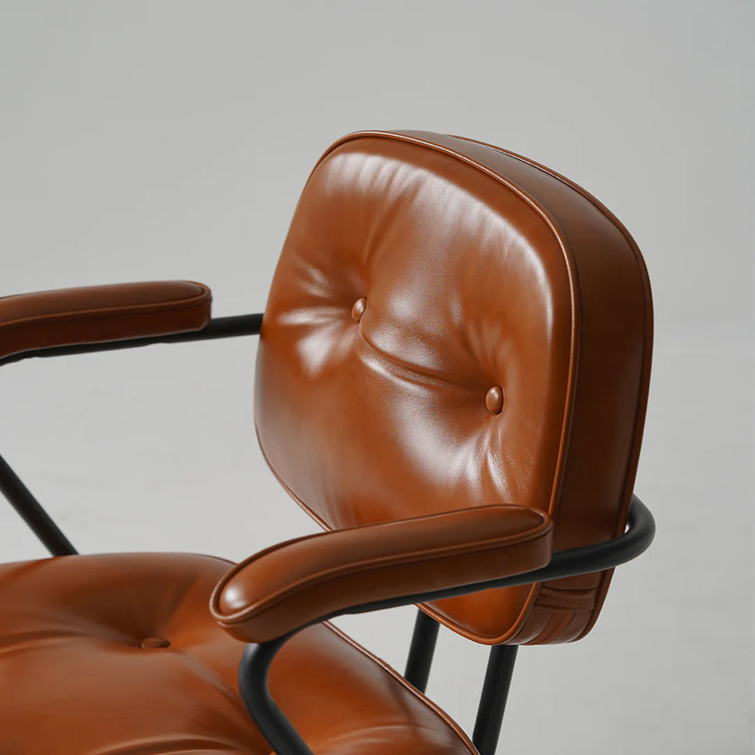 Brown leather chair with black metal frame on a gray background