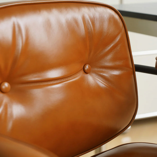Close-up of a brown leather chair with visible stitching