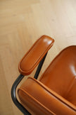 Close-up of a brown chair with a wooden floor background