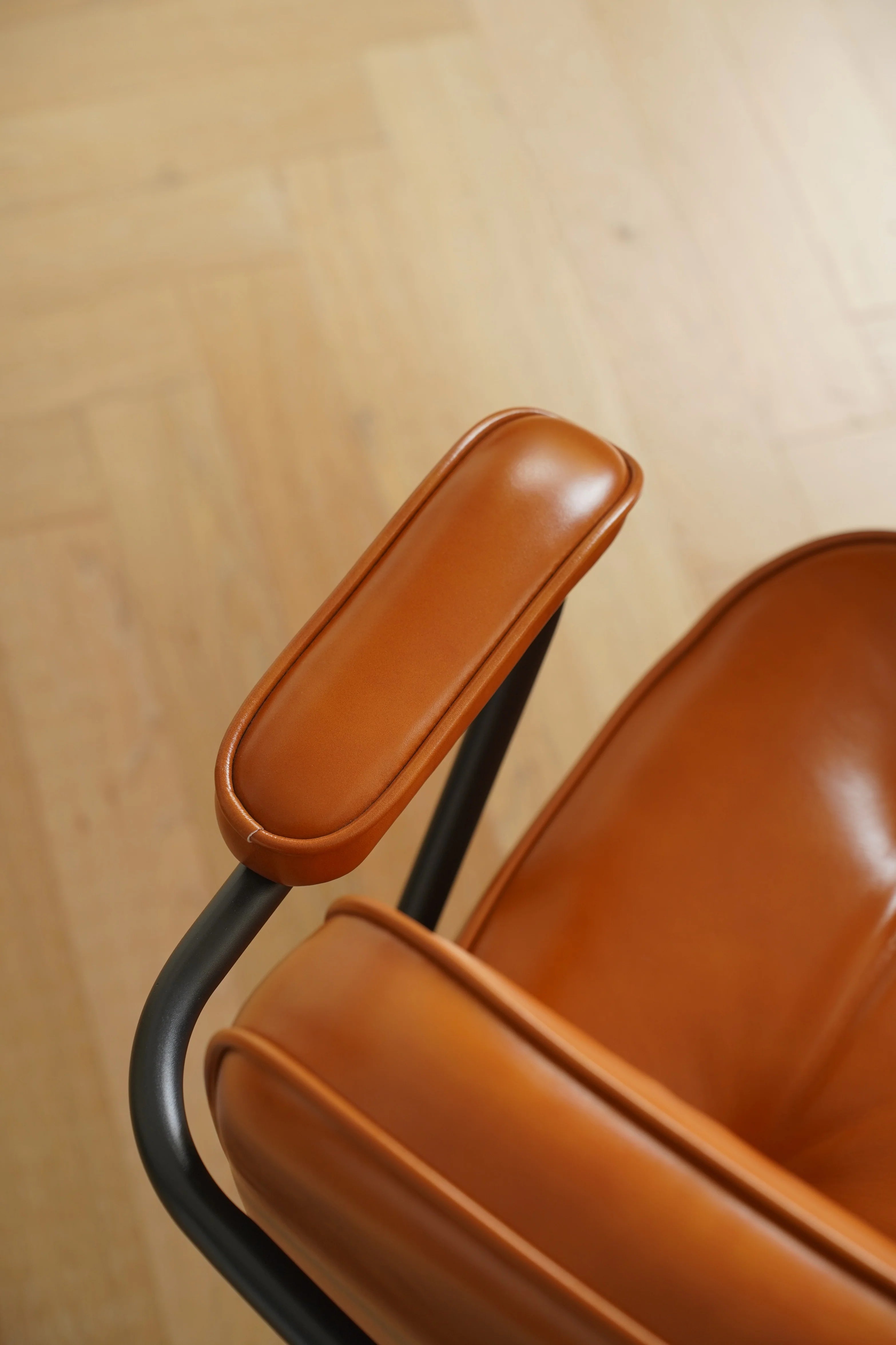 Close-up of a brown chair with a wooden floor background
