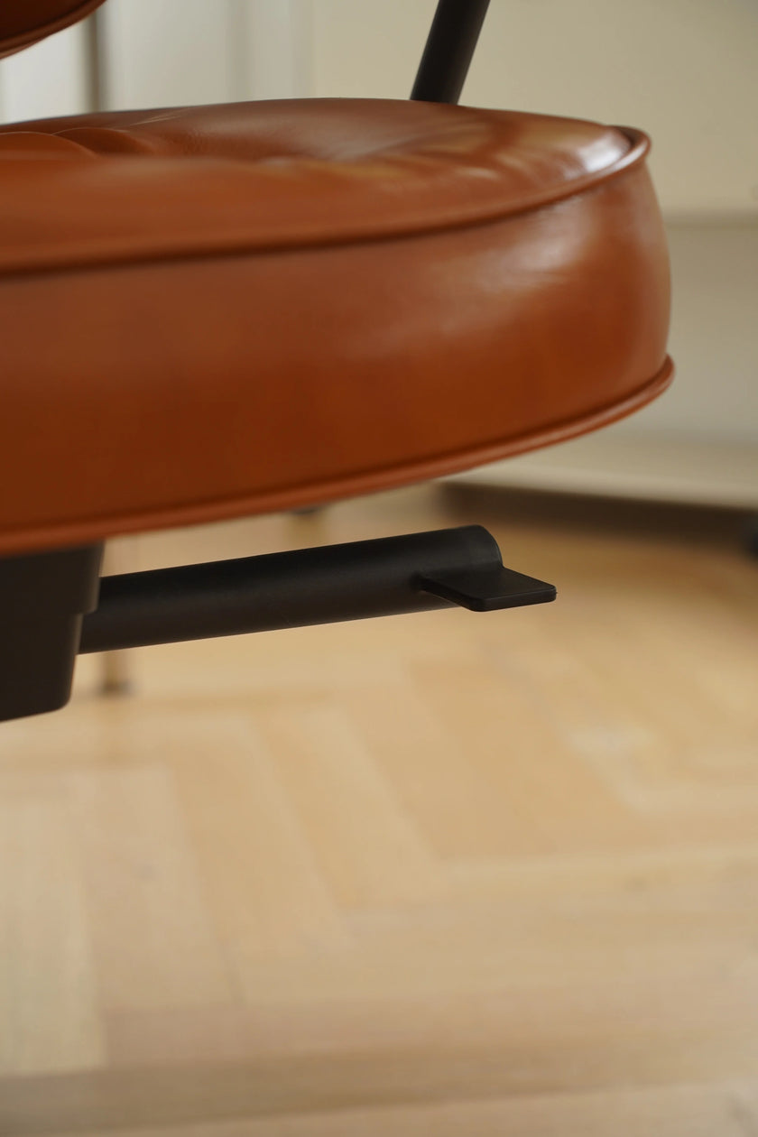 Close-up of a brown leather chair seat with a blurred background