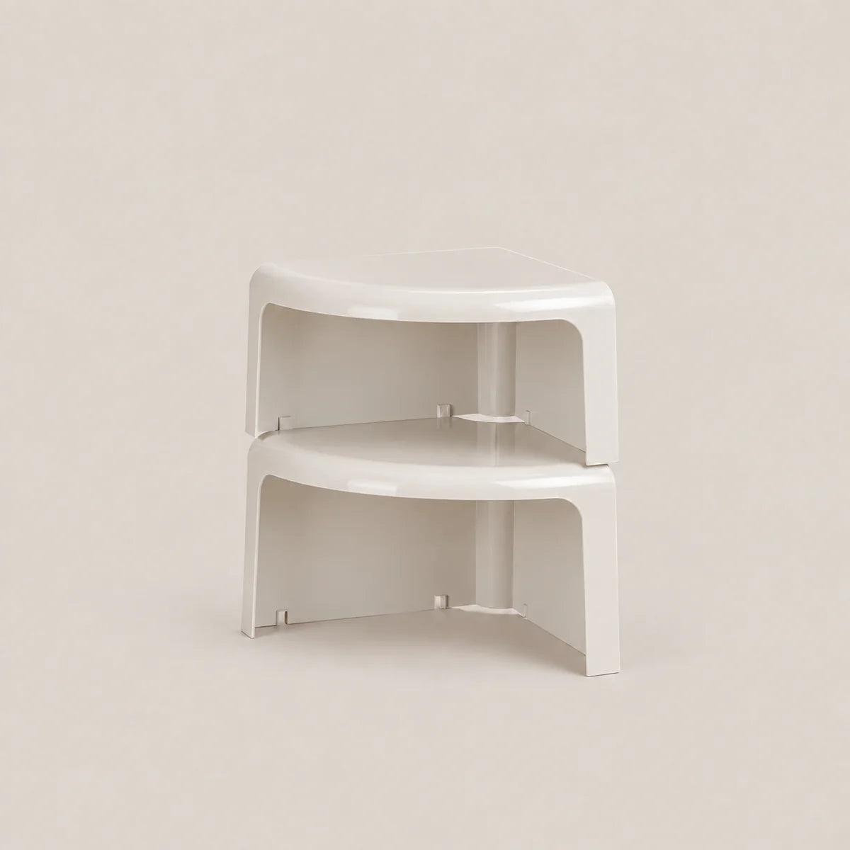 A pair of white plastic corner shelf risers stacked together on a light beige background.