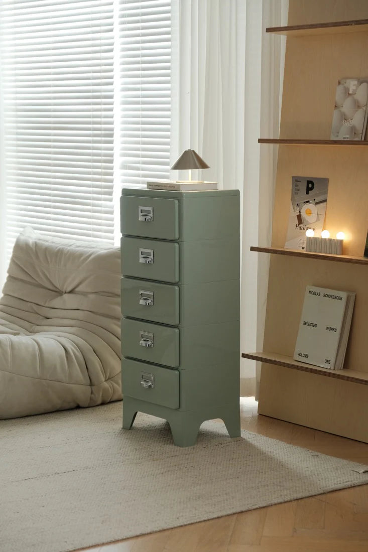 Green metal cabinet with drawers in a room with a couch and shelves.