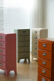 Set of colorful drawers in red, green, beige, and orange against a neutral background.