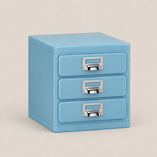 A light blue three-drawer file cabinet with silver metal pull handles, shown on a solid beige background.