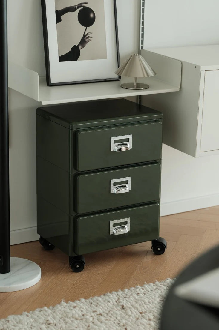 Green abs file cabinet with three drawers in a room setting.