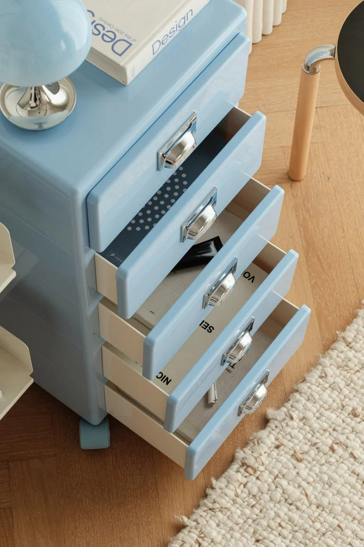 Blue nightstand with multiple drawers on a wooden floor.