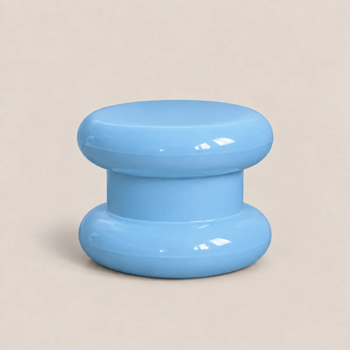 A glossy light blue plastic knob or dial with a rounded mushroom-shaped design, set against a solid beige background.