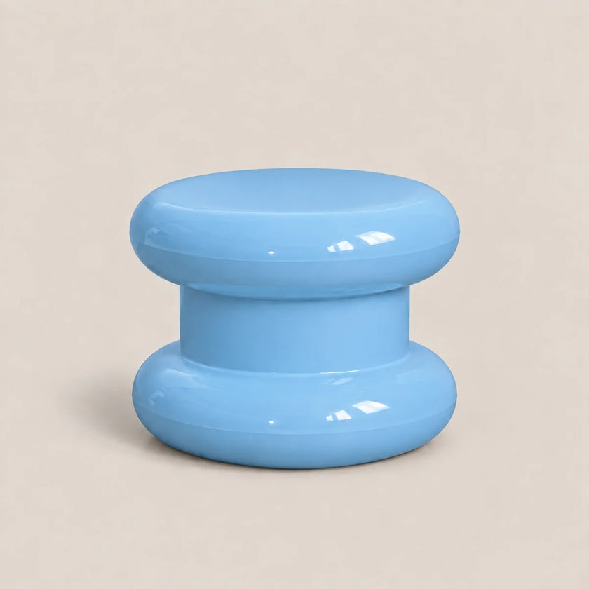 A glossy light blue plastic knob or dial with a rounded mushroom-shaped design, set against a solid beige background.