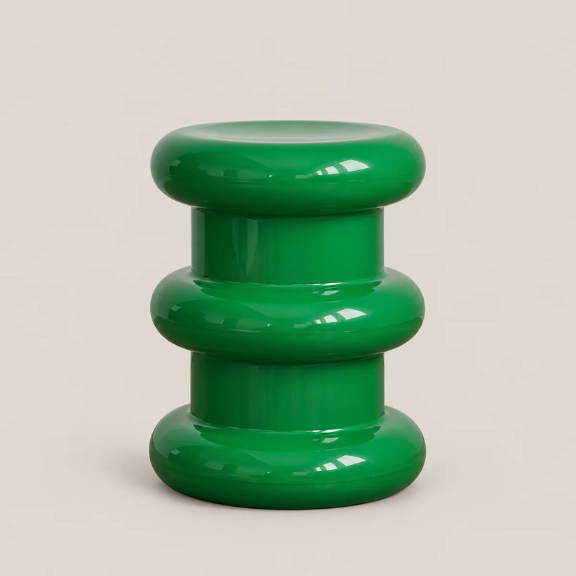 A glossy green modern stool with a stacked, rounded tiered design, photographed against a solid light beige background.