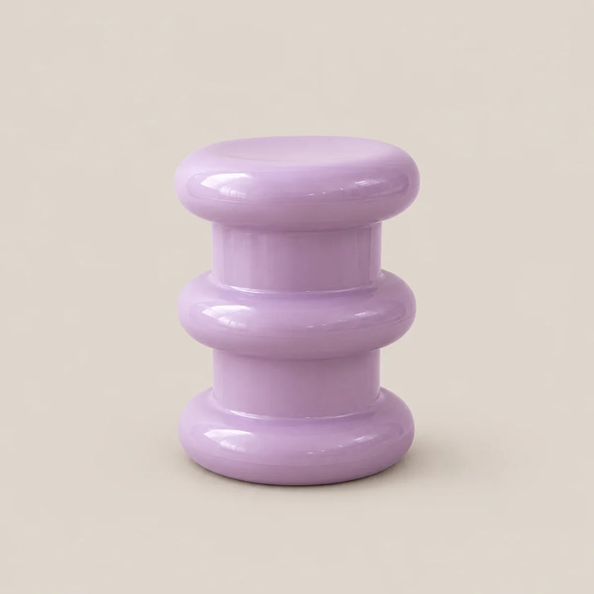 A small round side table with a glossy lavender purple finish, featuring three stacked circular tiers, set against a solid beige background.