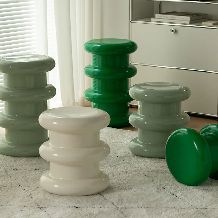 Set of colorful stools in a room with a neutral background
