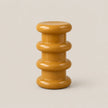 A glossy mustard yellow side stool with a stacked, rounded tiered design on a light beige background.
