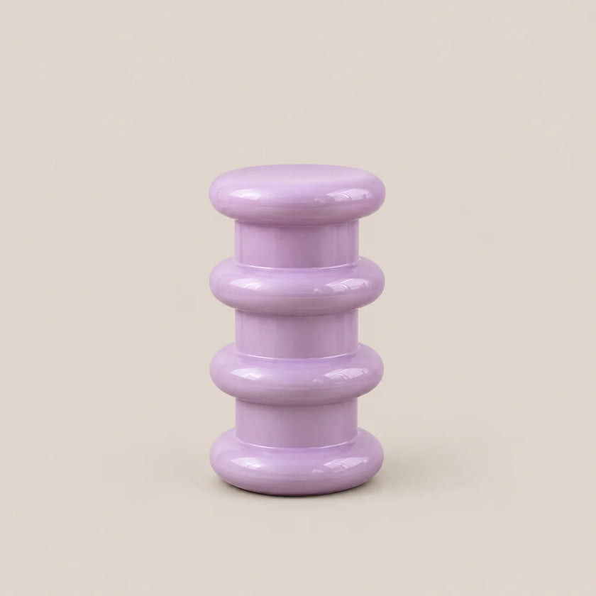 A small lavender purple side table with a glossy finish, featuring a stacked, rounded tiered design on a solid beige background.