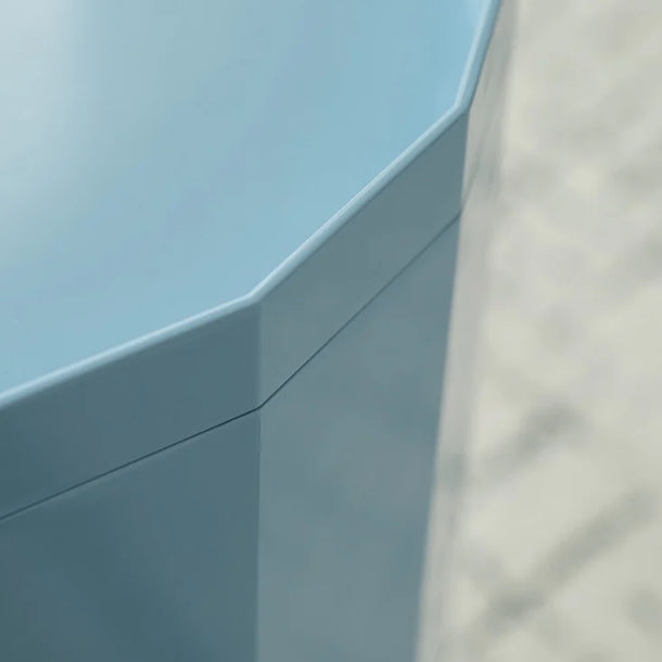 Close-up of a light blue corner desk with a neutral background